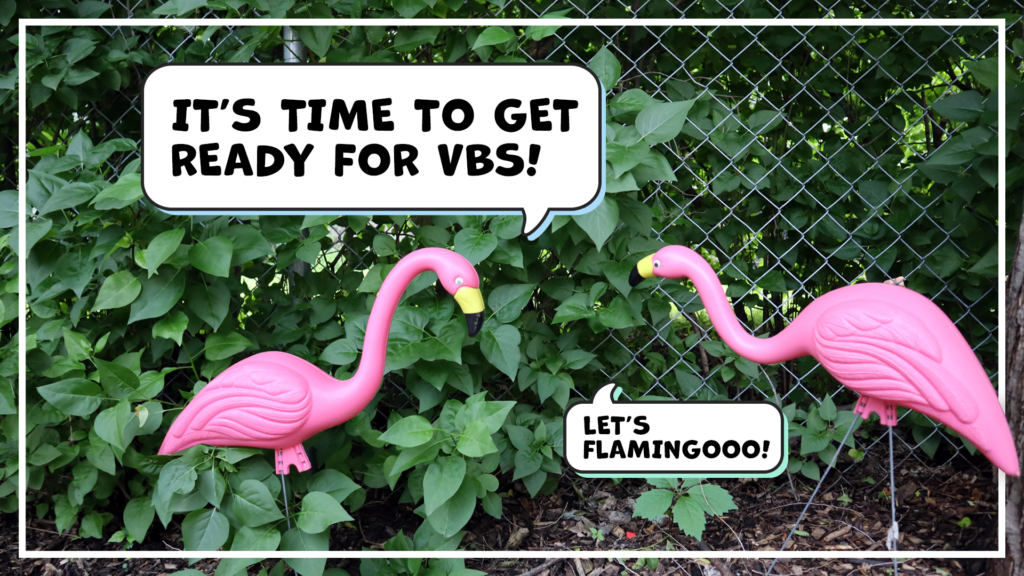 Two pink lawn flamingos standing in front of a leafy chainlink fence, each with a speech bubble. "It's time to get ready for VBS!" the left flamingo says. "Let's flamingooo!" says the one on the right. 